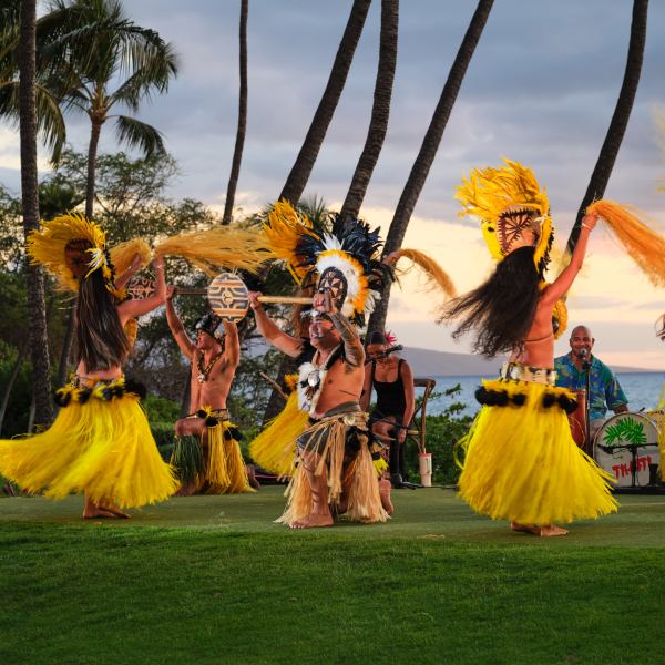 Group of dancers in colorful costumes performing outdoors.